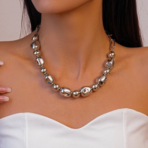 Close-up of chunky silver irregular metal beads on a woman's collarbone necklace