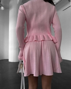 Vue arrière de l'ensemble deux pièces en tricot rose avec manches volantées et minijupe