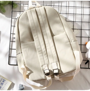 Detail view of the off-white canvas backpack back with padded straps and side pockets