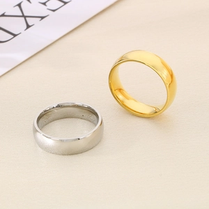 Polished 6mm stainless steel rings in gold and silver finish on beige fabric background