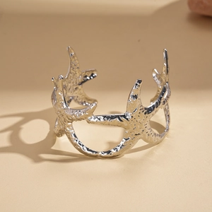 Detailed view of silver starfish open cuff bracelet with matte textured relief design