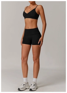 Close-up of black V-neck sports bra and high-waisted shorts with seamless matte texture