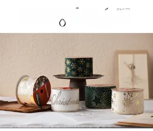 Detail of dark green and white Christmas ribbons with gold snowflake and elk patterns
