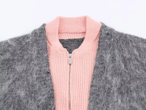 Detail of the gray faux fur collar with a pink ribbed knit inner layer and metal zipper