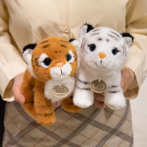 Adorable plush tiger dolls in orange and white colors held in hands, soft stuffed toys
