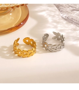 Detailaufnahme der Blattmuster-Ringe in Gold und Silber auf minimalistischer Fläche
