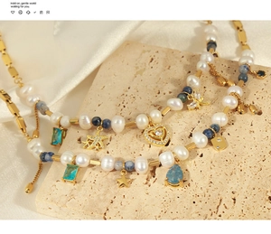 Détail d'un collier en perles avec pierres bleues et breloques dorées sur pierre naturelle
