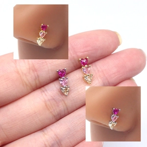 Macro view of triple heart nose studs in gold and silver finish with colorful gems