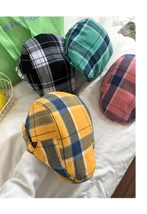 Détail des casquettes plates à carreaux en quatre couleurs avec boucles en métal sur le côté