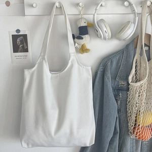 Minimalist plain white cotton canvas tote bag hanging with aesthetic lifestyle accessories