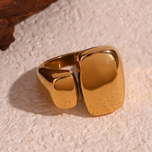 Détail d'une bague ouverte en acier plaqué or 18 carats sur une surface en pierre texturée