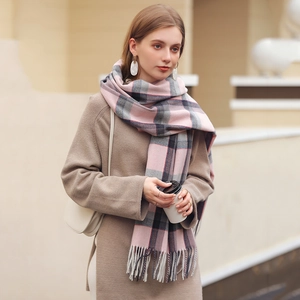 Elegant pink plaid cashmere feel scarf with fringe tassels worn by a model in winter