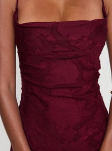 Close-up of wine red floral jacquard fabric texture on a slim fit bodycon dress