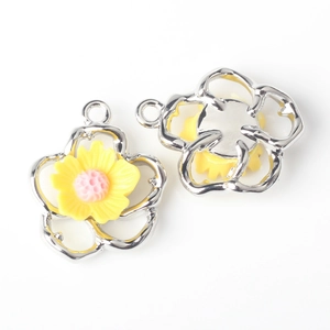 Detail of silver hollow flower charms with yellow and pink resin petals for DIY jewelry