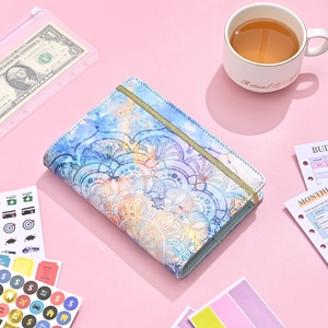 Flat lay of A6 PU leather budget binder with mandala pattern and gold elastic band