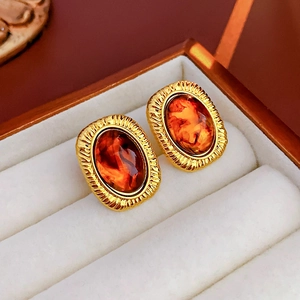 Macro shot of vintage amber resin earrings with gold metal frame in a velvet jewelry box