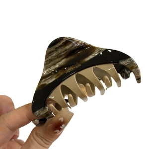 Two-tone marble hair claw clip with gold label and acetate tortoiseshell pattern