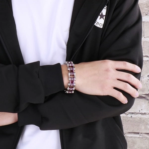 Detail of industrial punk style stainless steel bicycle chain bracelet in silver and purple