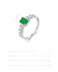 Macro detail of 925 sterling silver ring with emerald cut green gem and leaf band