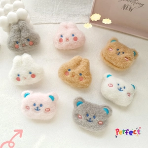 Close-up of plush rabbit and bear patches with detailed embroidery on linen fabric