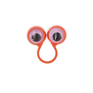 Close-up of an orange plastic novelty ring featuring large googly eyes for parties