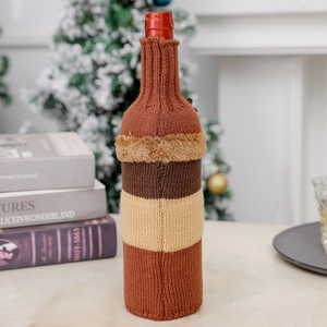 Detail of striped knitted Christmas wine bottle cover with soft faux fur trim and cozy decor