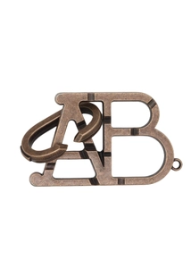 Gros plan sur un casse-tête en métal bronze avec formes de lettres AB sur fond blanc