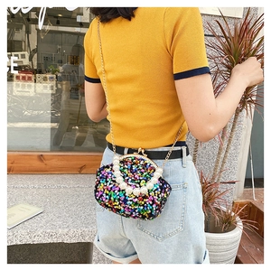 Detailed shot of sparkling sequin mini bag with pearl handle and metal chain strap