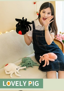 Detailed plush spider toys in black, pink, and white shown in a cozy home setting