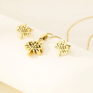 Golden stainless steel Tree of Life jewelry set with necklace and earrings on white stand