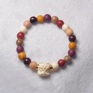 Detailed close-up of a multi-color beaded bracelet with white beast carving on fur background