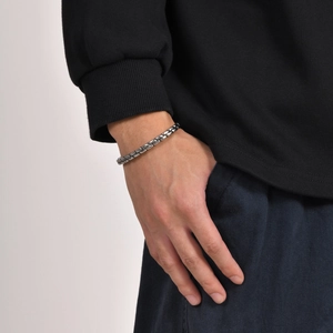 Close-up of vintage silver braided stainless steel bracelet on male model's wrist