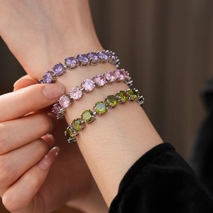 Detailed view of silver tennis bracelets featuring lavender, pink and olive green zircons