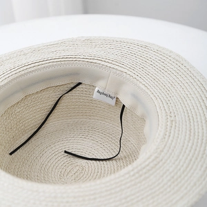Detail view of woven straw sun hat interior featuring sweatband and adjustable drawstring