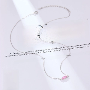 Macro shot of S925 silver necklace with pink marquise zircon on a magazine background