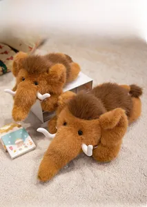 Detail of plush mammoth dolls with realistic long fur and curved tusks on soft beige carpet