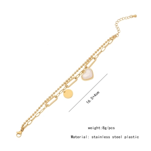Detail of double-layer gold stainless steel bracelet with heart and round charms