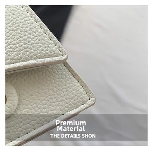 Close-up of white lychee-patterned leather fabric and fine stitching detail on mini bag