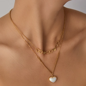 Détail du collier double rang en or avec cœurs et pendentif irisé sur modèle