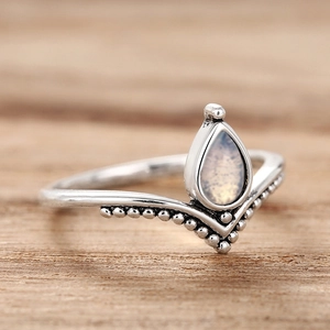Dettaglio macro dell'anello con pietra di luna a goccia, fascia a V e perline vintage