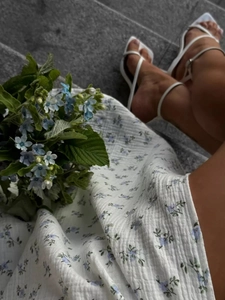 Close-up of white floral cotton fabric texture and stylish square-toe sandals