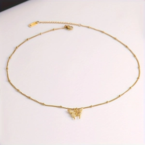 Elegant gold butterfly pendant necklace with delicate beaded chain on a white background