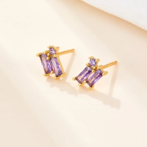 Macro shot of gold S925 silver stud earrings with rectangular purple zircon stones