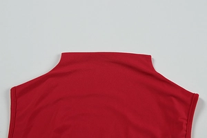 Detail of red sleeveless dress showing mock neck collar and fine knit fabric texture