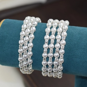 Close-up of multi-layer pearl and rhinestone open bracelet on a velvet stand