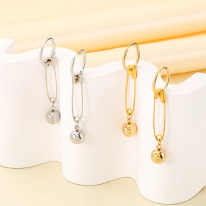 Detailed close-up of golden and silver safety pin drop earrings with metallic beads