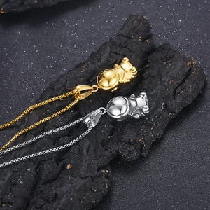 Macro view of gold and silver astronaut pendants on black rock for a hip-hop style look