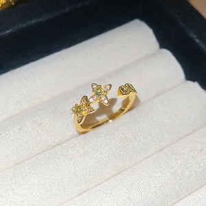 Detail of 18k gold plated star ring with green zircon stones on white display