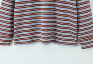 Detail shot of blue and brown striped knit sweater showing hem and cuff stitching