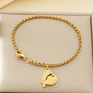 Détail d'un bracelet en acier doré avec pendentif en cœur orné de cristaux étincelants